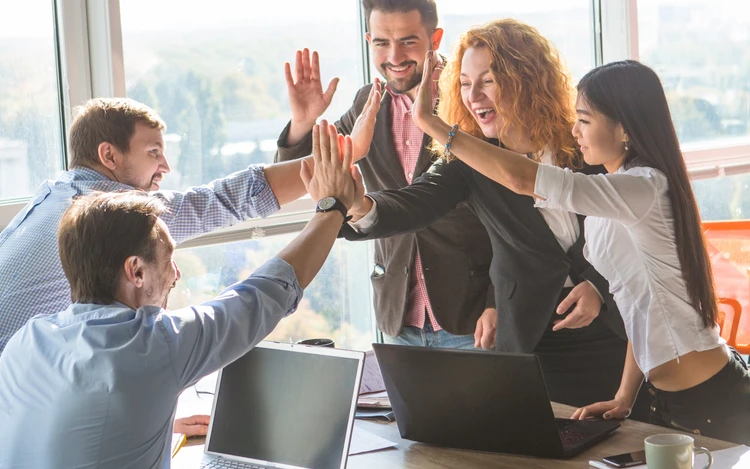 Giovani professionisti in team soddisfatti degli obiettivi raggiunti lavorativamente