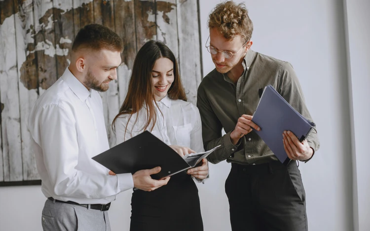 Giovani professionisti in un open space che collaborano su progetti digitali e green